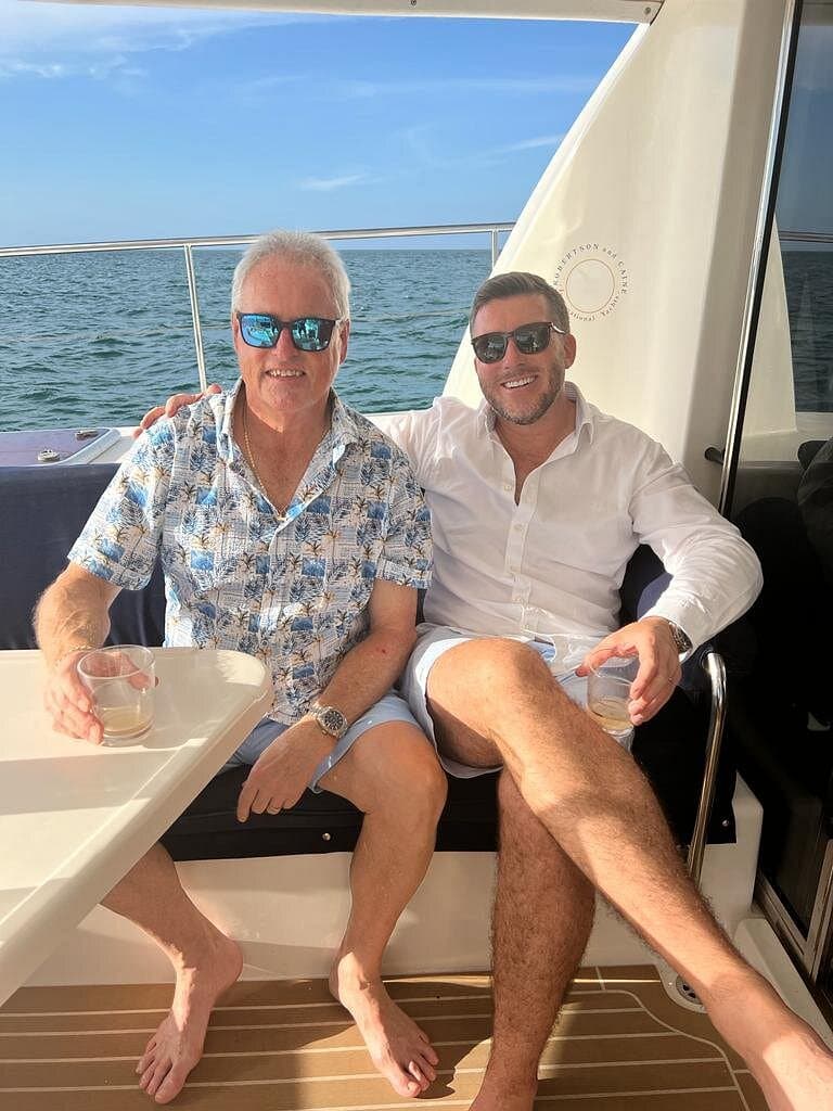 Guests relaxing with drinks on the aft deck of the 47' power catamaran