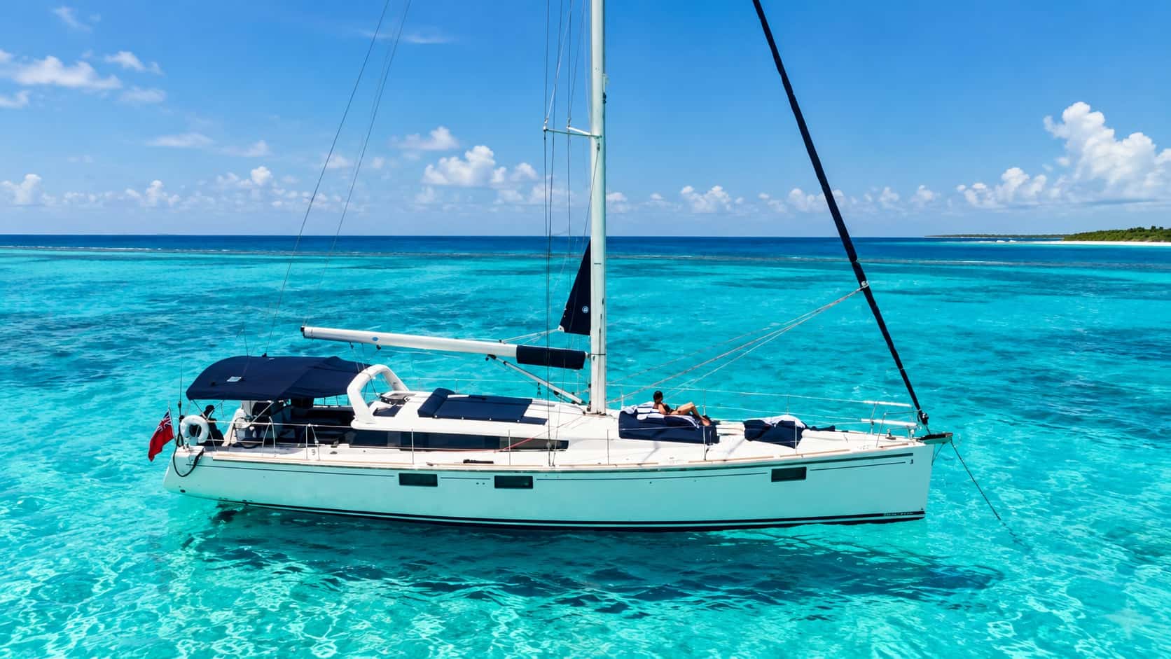 The 55ft luxury sailing yacht anchored over turquoise shallows off Grand Cayman